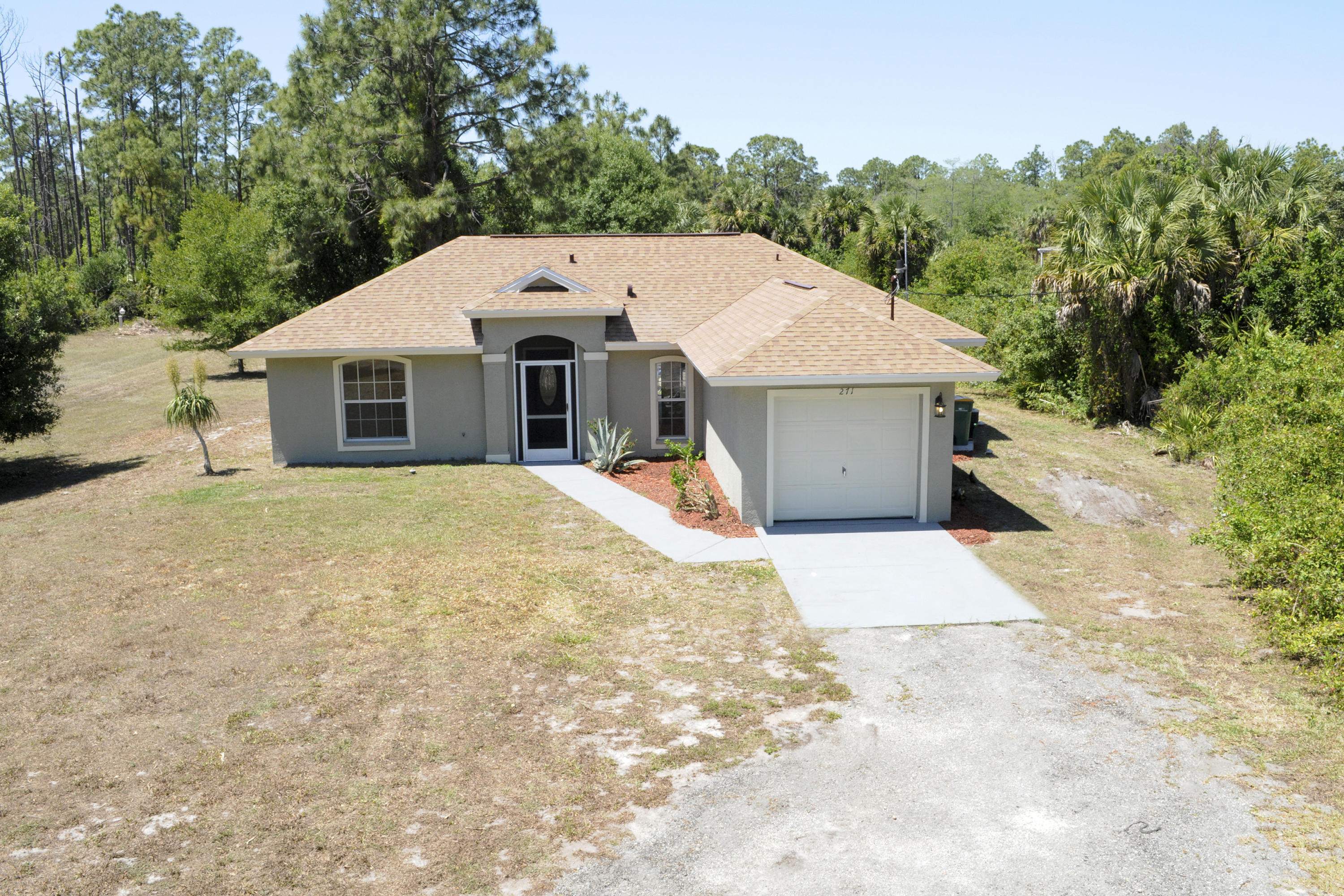 271 18th Street Southeast Naples, FL 34117 - Photo 1 of 28 a view of a white house with a yard and large tree