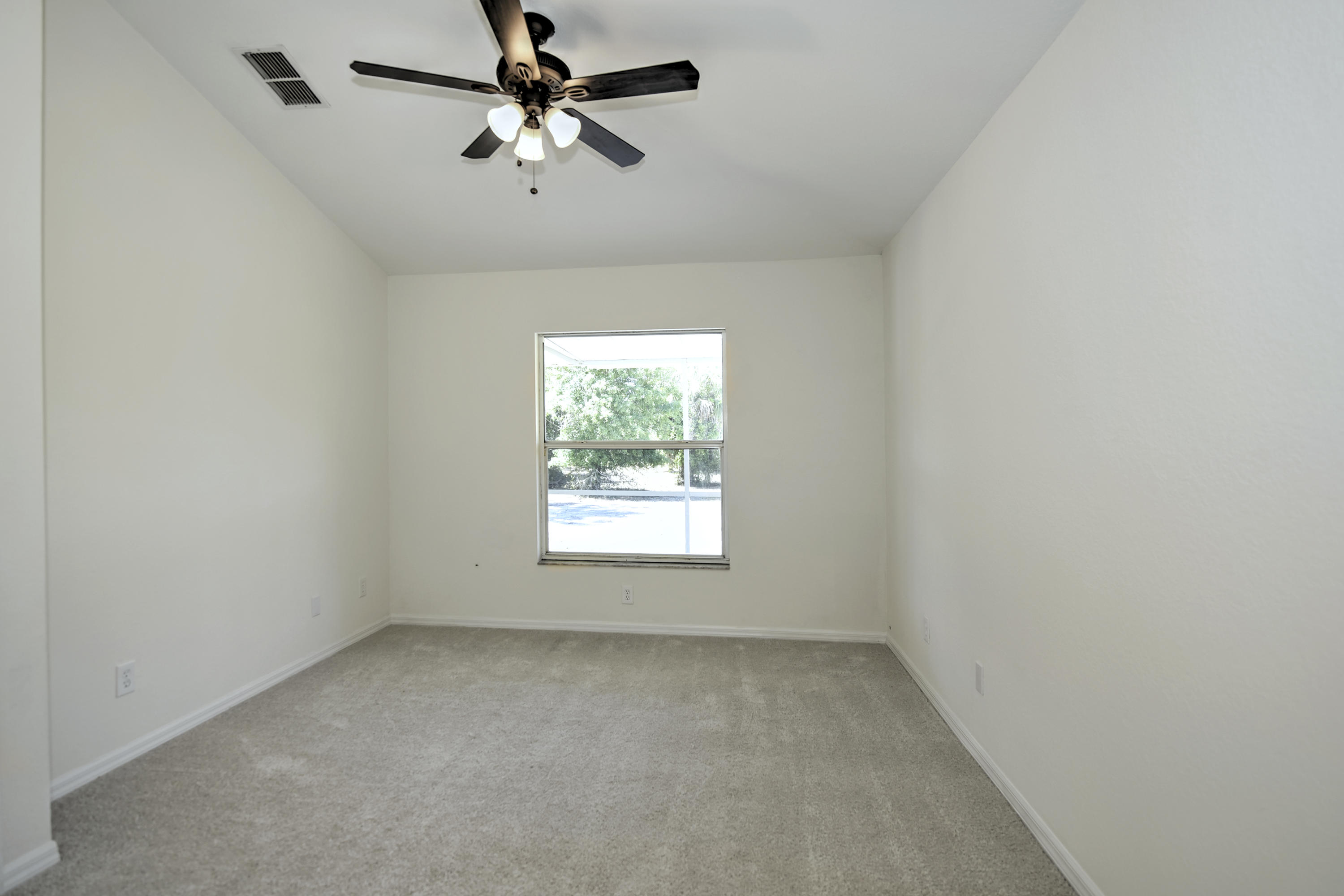 271 18th Street Southeast Naples, FL 34117 - Photo 11 of 28 an empty room with a window and a fan