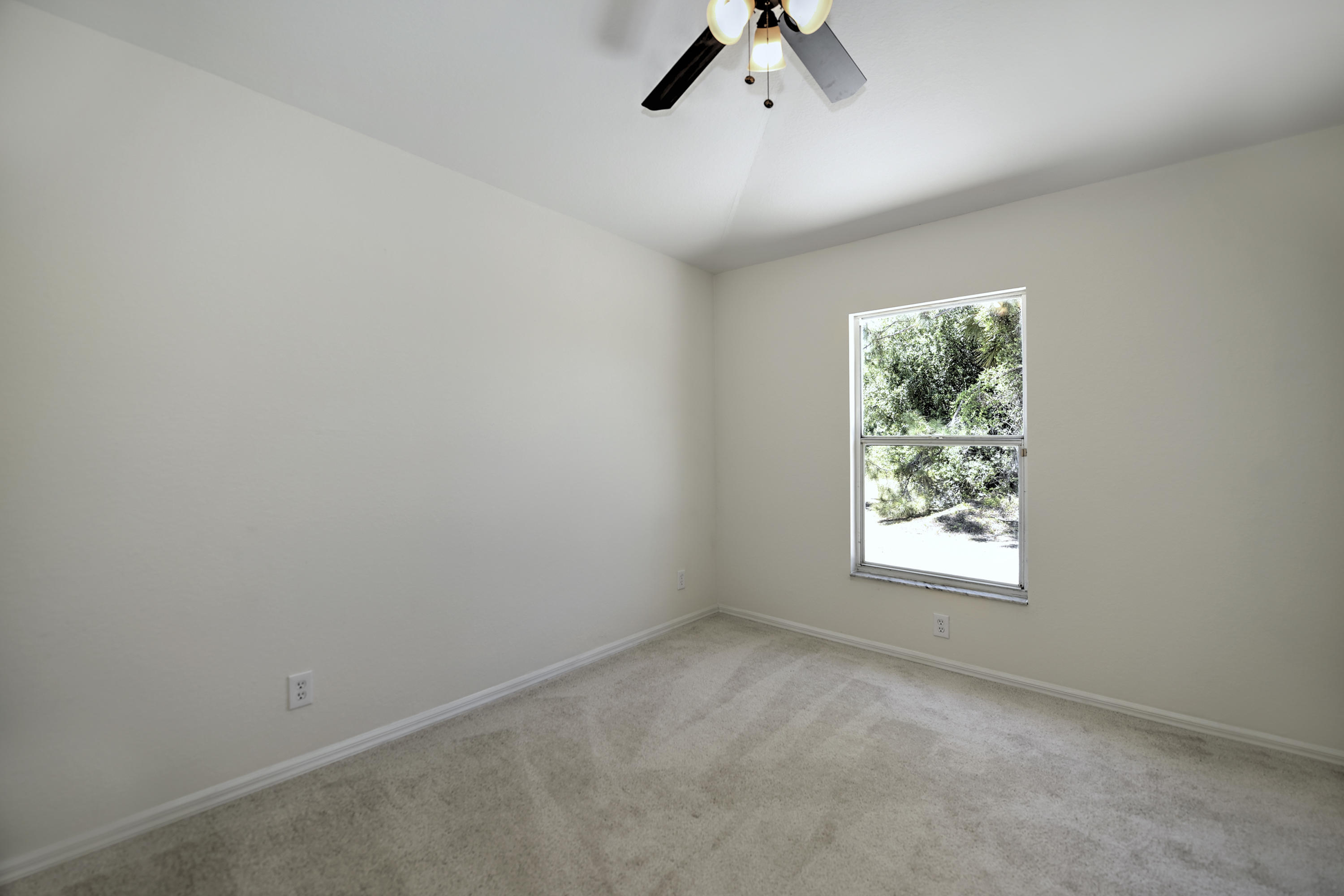 271 18th Street Southeast Naples, FL 34117 - Photo 21 of 28 an empty room with a window and a ceiling fan
