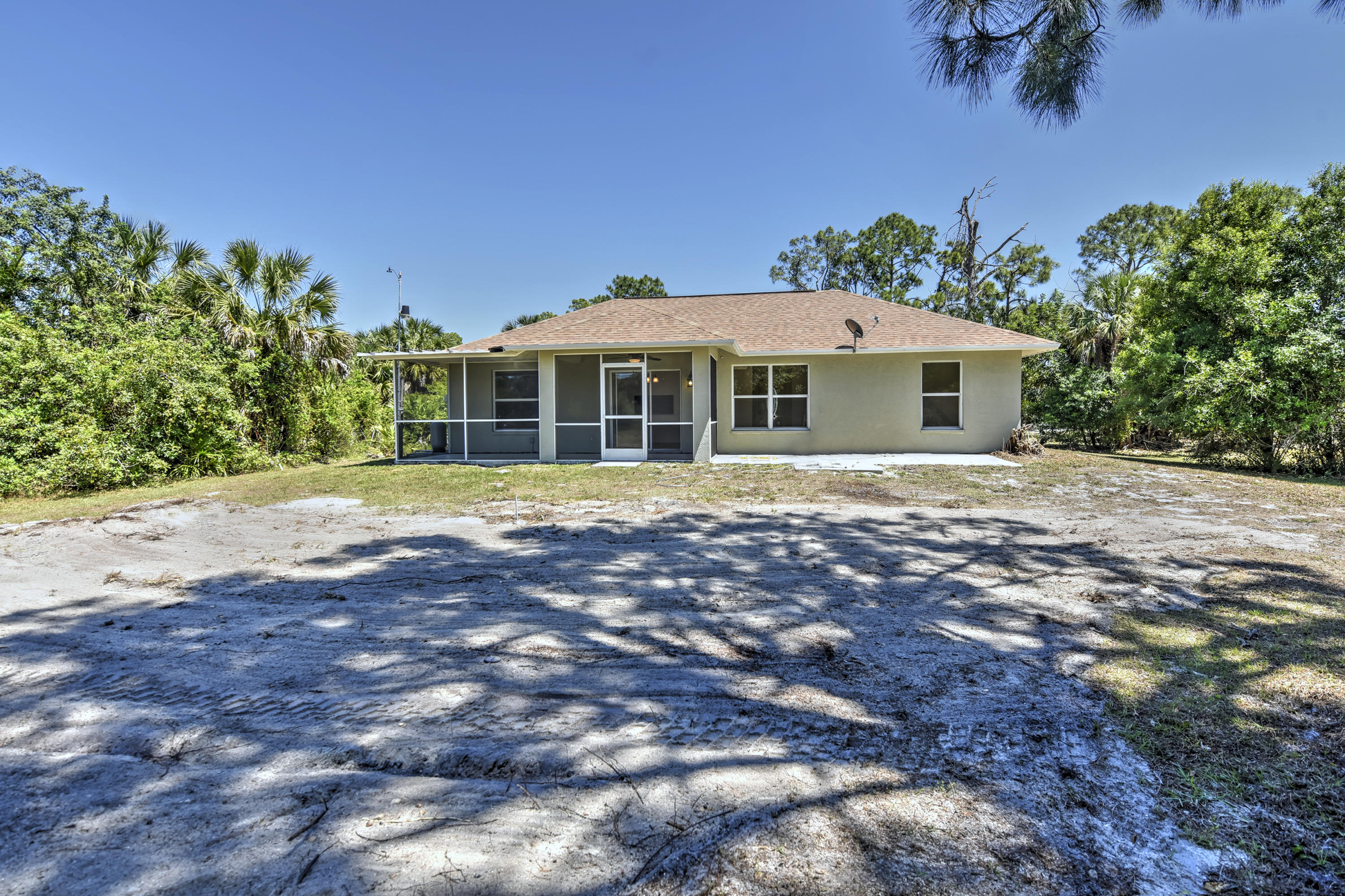 271 18th Street Southeast Naples, FL 34117 - Photo 26 of 28 a front view of a house with a yard and trees