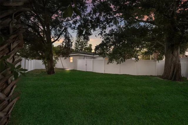 a view of a backyard with large trees