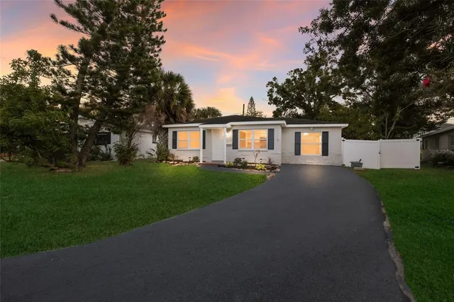 a front view of a house with a yard and trees