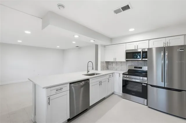 a kitchen with a sink stainless steel appliances and counter space
