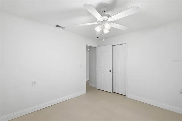 an empty room with a fan and a fan