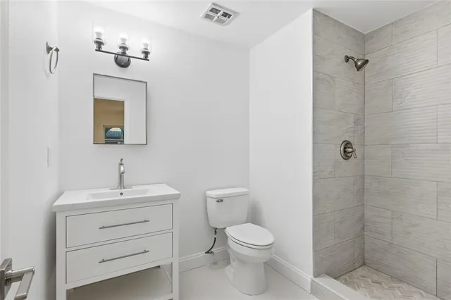 a bathroom with a toilet a sink a mirror and vanity