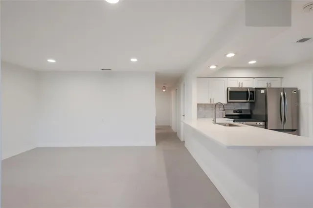 a view of kitchen with stainless steel appliances kitchen island