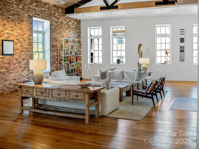 a living room with furniture a wooden floor and a large window