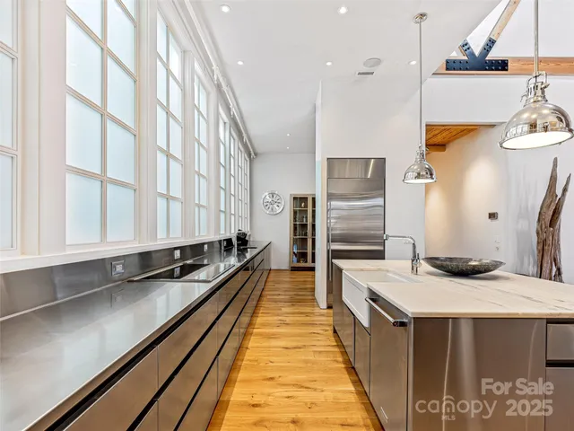 a kitchen with stainless steel appliances a sink a stove and a refrigerator