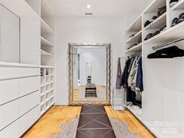 a view of walk in closet with clothes and shoes