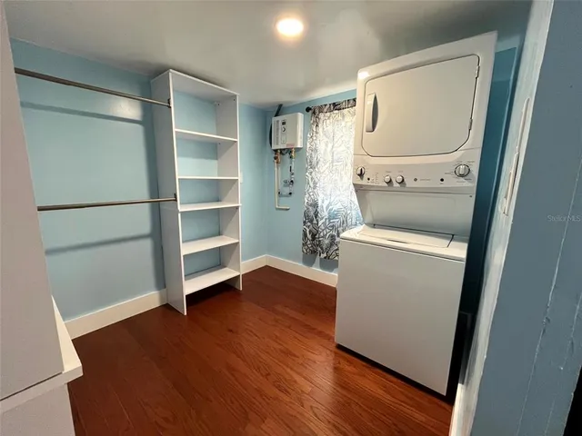 a view of walk in closet with wooden floor and washer
