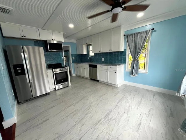 a kitchen with stainless steel appliances a refrigerator sink and microwave