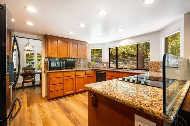 a kitchen with stainless steel appliances granite countertop sink stove and cabinets