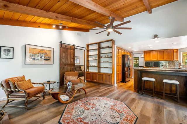 a living room with a bed furniture flat screen tv and a fireplace