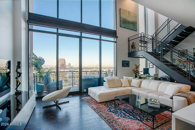 a living room with patio furniture and a floor to ceiling window