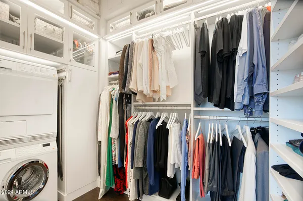 a view of walk in closet with clothes and shoes