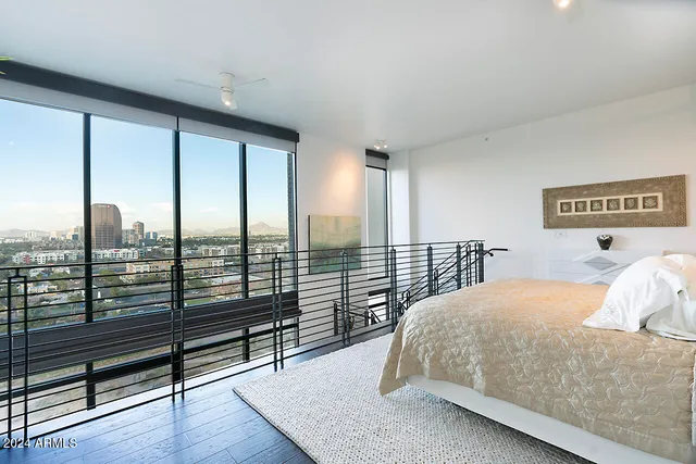 a bedroom with a large window and bed