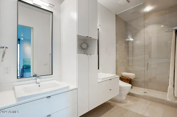 a bathroom with a double vanity sink toilet and shower
