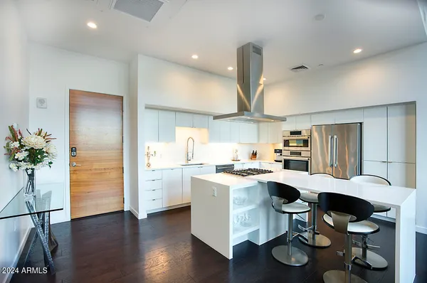 a open kitchen with white cabinets and stainless steel appliances