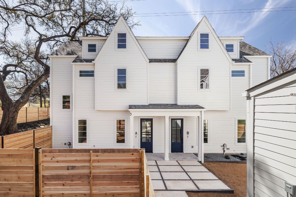 View of front of house with a shingled roof and a patio