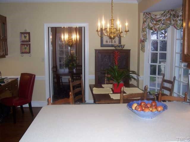 7909 Sutterton Court Raleigh, NC 27615 - Photo 5 of 12 a living room filled with furniture and chandelier