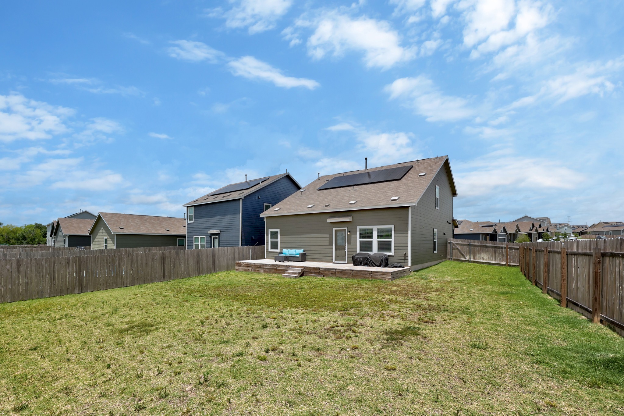 14121 Berning Road Manor, TX 78653 - Photo 23 of 27 A spacious backyard awaits, complete with a generous wooden deck, perfect for outdoor enjoyment.