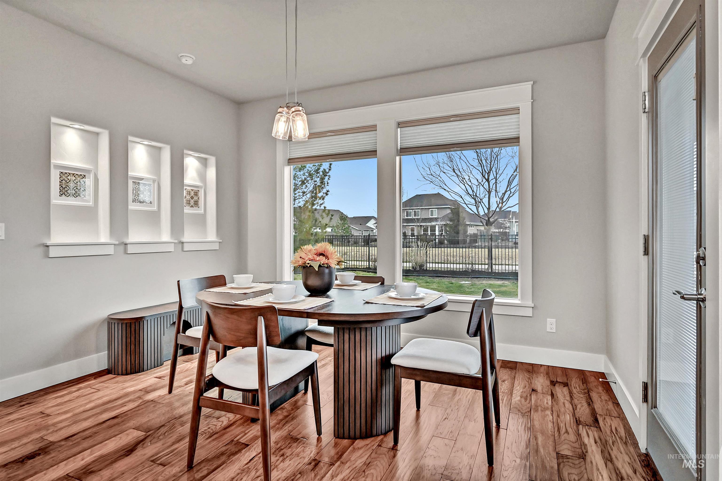 5802 South Wayland Way Meridian, ID 83642 - Photo 12 of 35 Dining area with engineered wood floors, large windows, and a door out to the covered patio