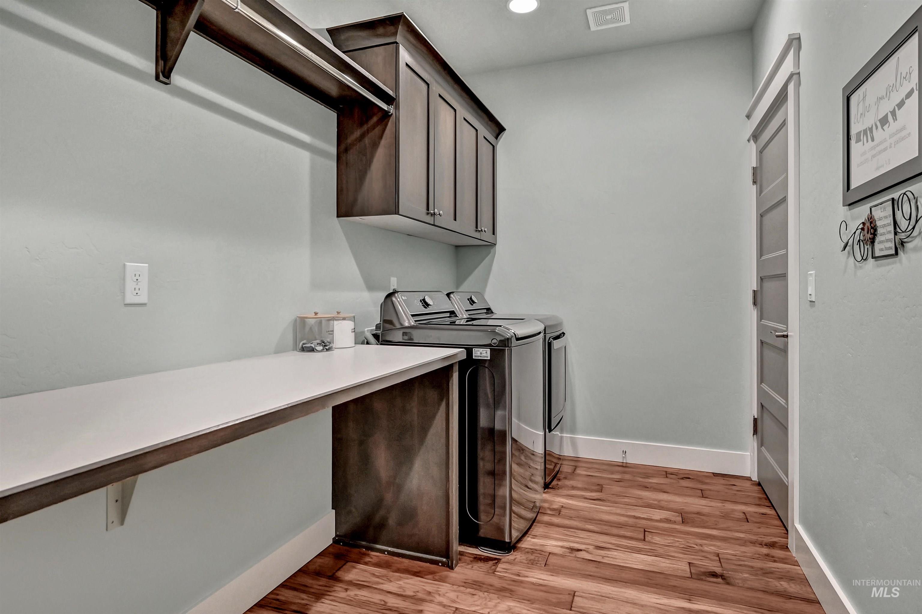 5802 South Wayland Way Meridian, ID 83642 - Photo 18 of 35 Laundry room connected to the primary bedroom walk-in closet, large counter space, dark cupboards, and a hanging rod