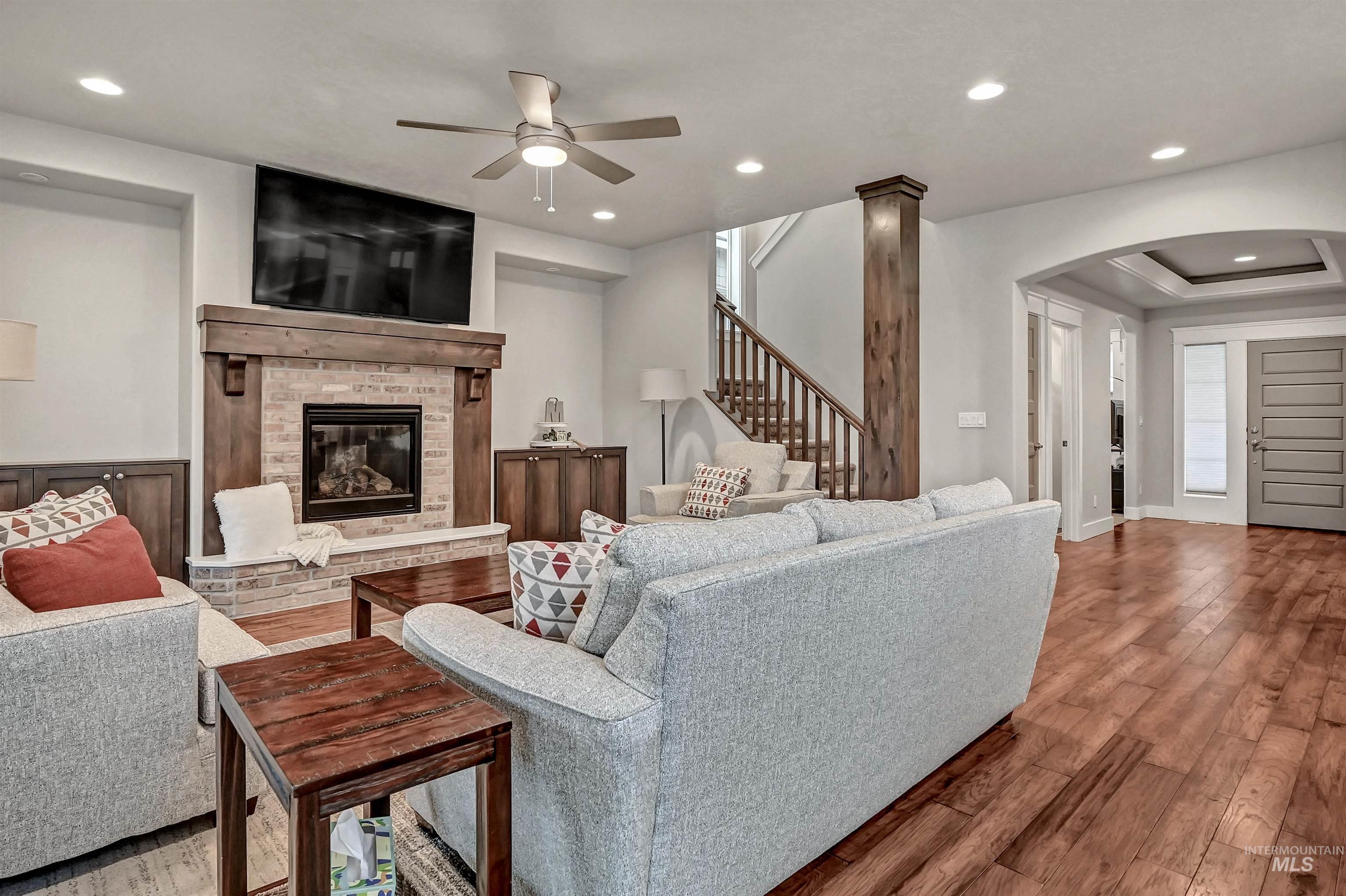 5802 South Wayland Way Meridian, ID 83642 - Photo 7 of 35 Open-style great room featuring engineered-wood flooring, a ceiling fan, a fireplace, and recessed lighting