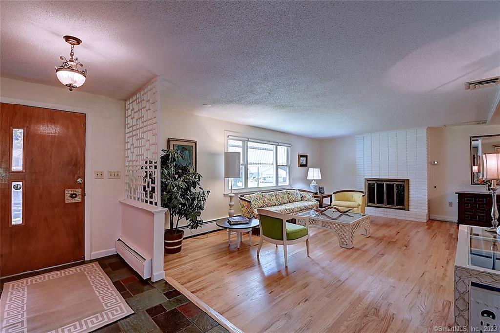 7 Cascade Road West Hartford, CT 06117 - Photo 1 of 1 a living room with fireplace furniture and a wooden floor