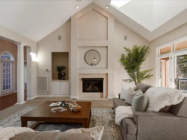 a living room with furniture a fireplace and a chandelier