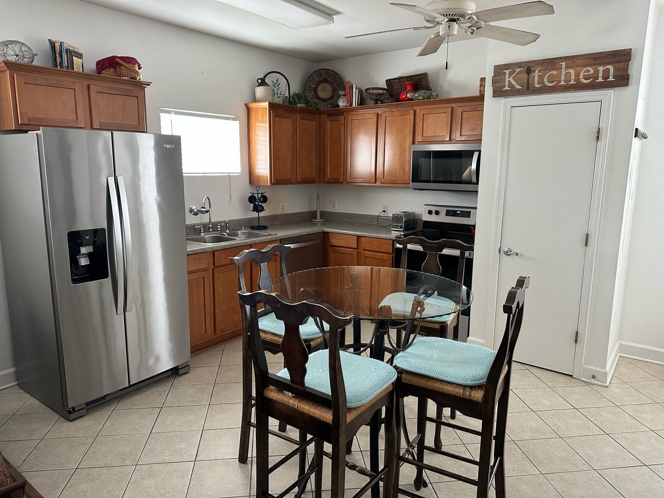 3754 West County Highway 30A, Unit 3 Santa Rosa Beach, FL 32459 - Photo 4 of 15 a kitchen with granite countertop a table chairs refrigerator and microwave