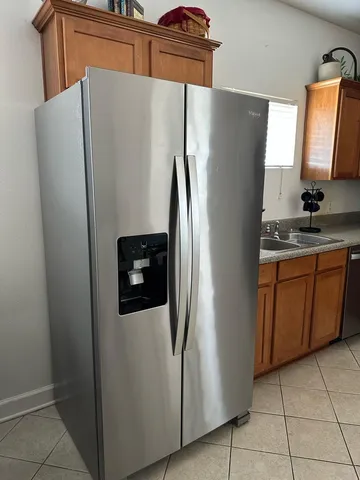 a metallic refrigerator freezer sitting in a kitchen
