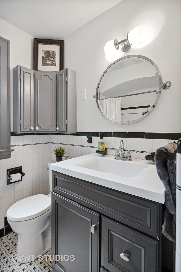 615 Riford Road Glen Ellyn, IL 60137 - Photo 14 of 33 a bathroom with a toilet a sink and mirror