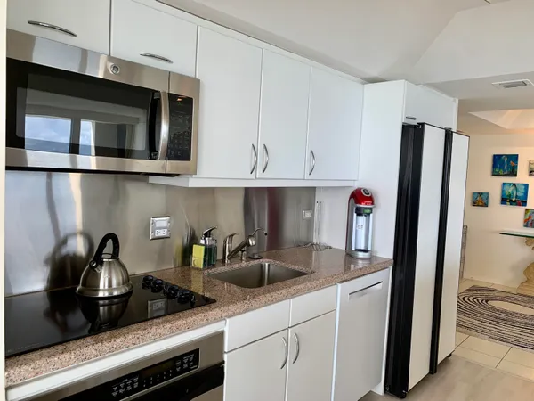 a kitchen with stainless steel appliances granite countertop a refrigerator and a sink