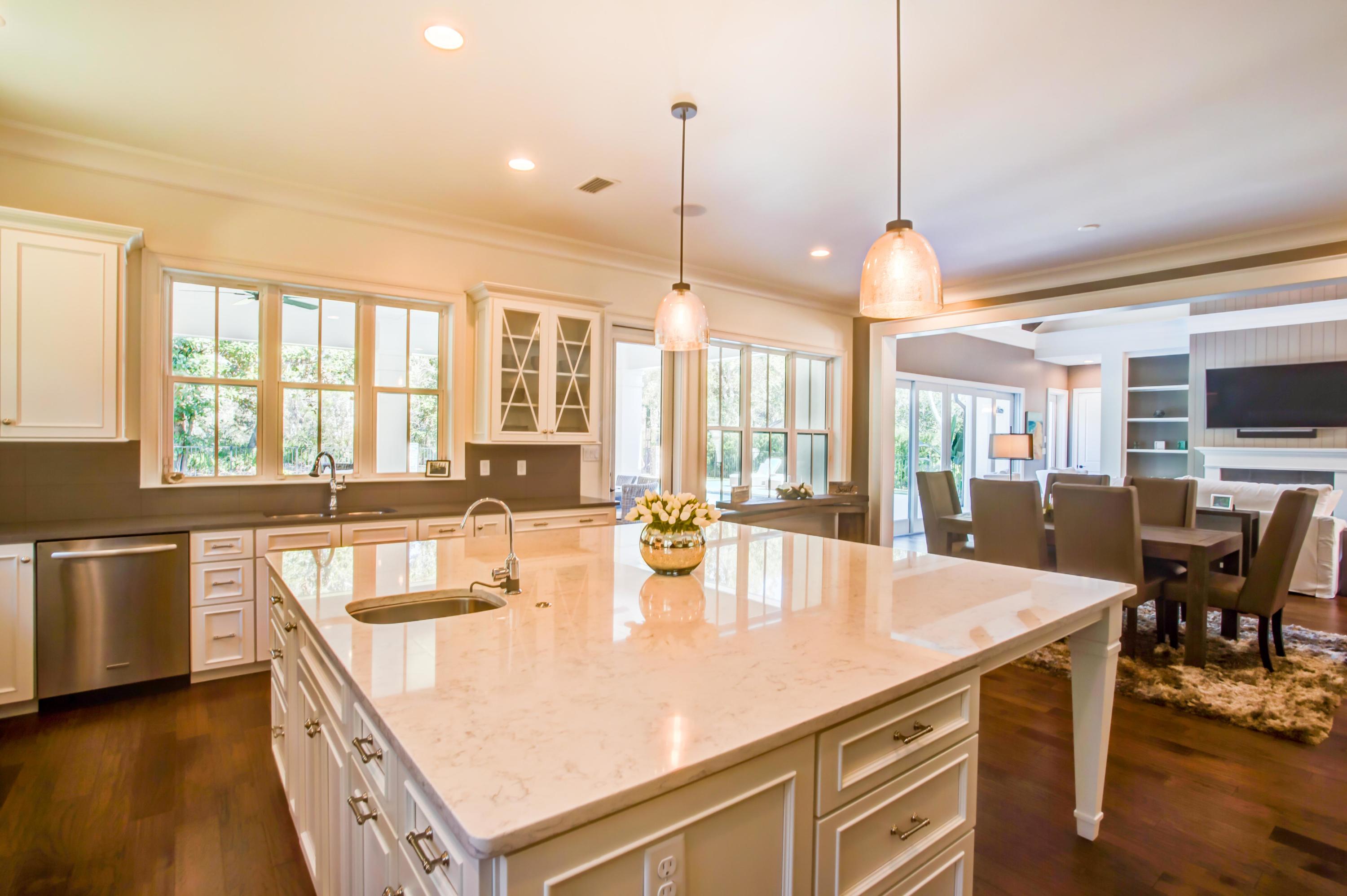 239 Mattie's Way Destin, FL 32541 - Photo 16 of 53 a kitchen with a stove a counter space dining table and chairs