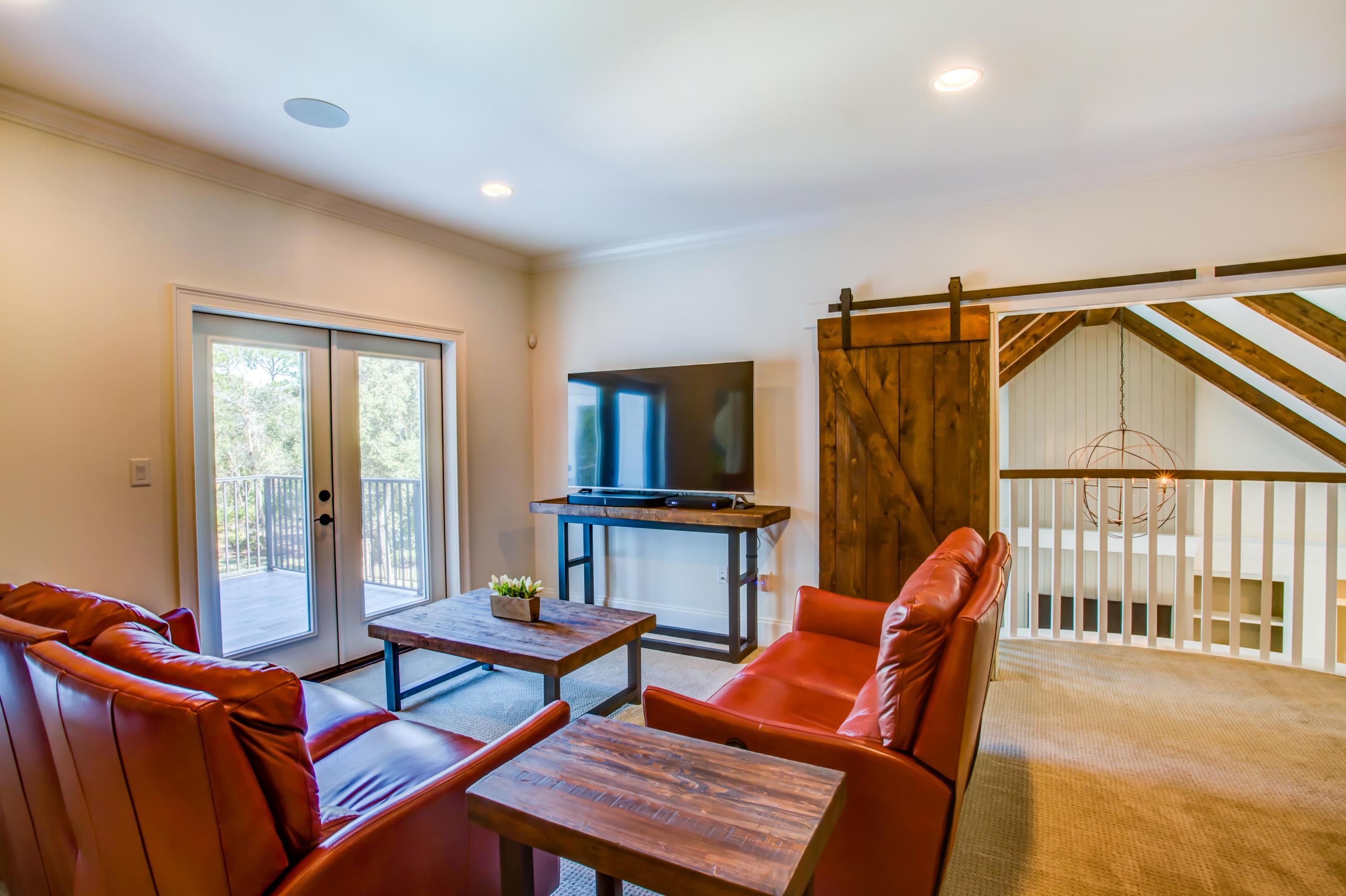 239 Mattie's Way Destin, FL 32541 - Photo 30 of 53 a living room with furniture a flat screen tv and a window