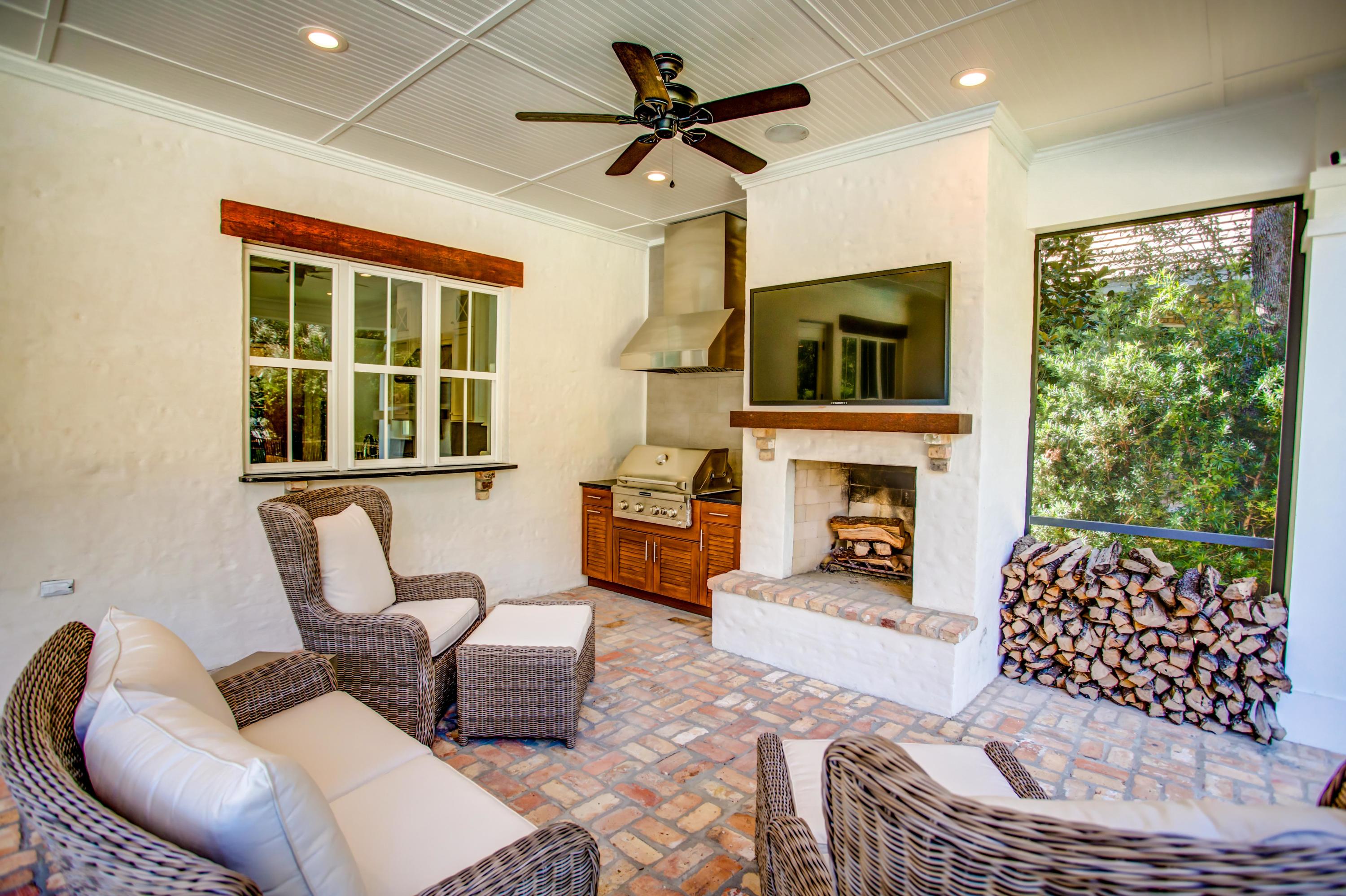 239 Mattie's Way Destin, FL 32541 - Photo 36 of 53 a living room with furniture a fireplace and a large window with garden view