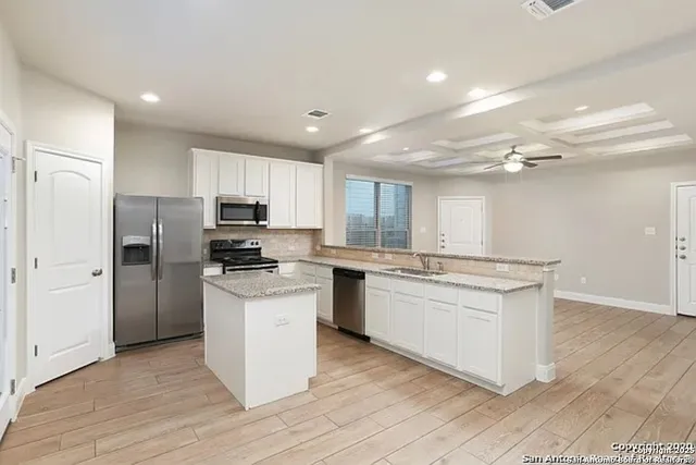 a kitchen with a refrigerator a sink dishwasher with a oven and cabinets