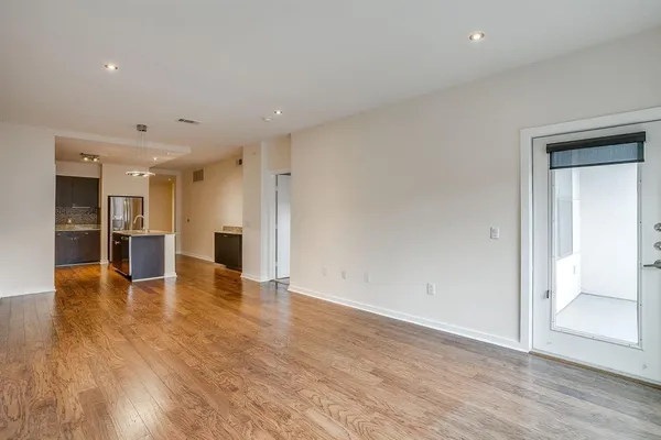 a view of empty room with wooden floor