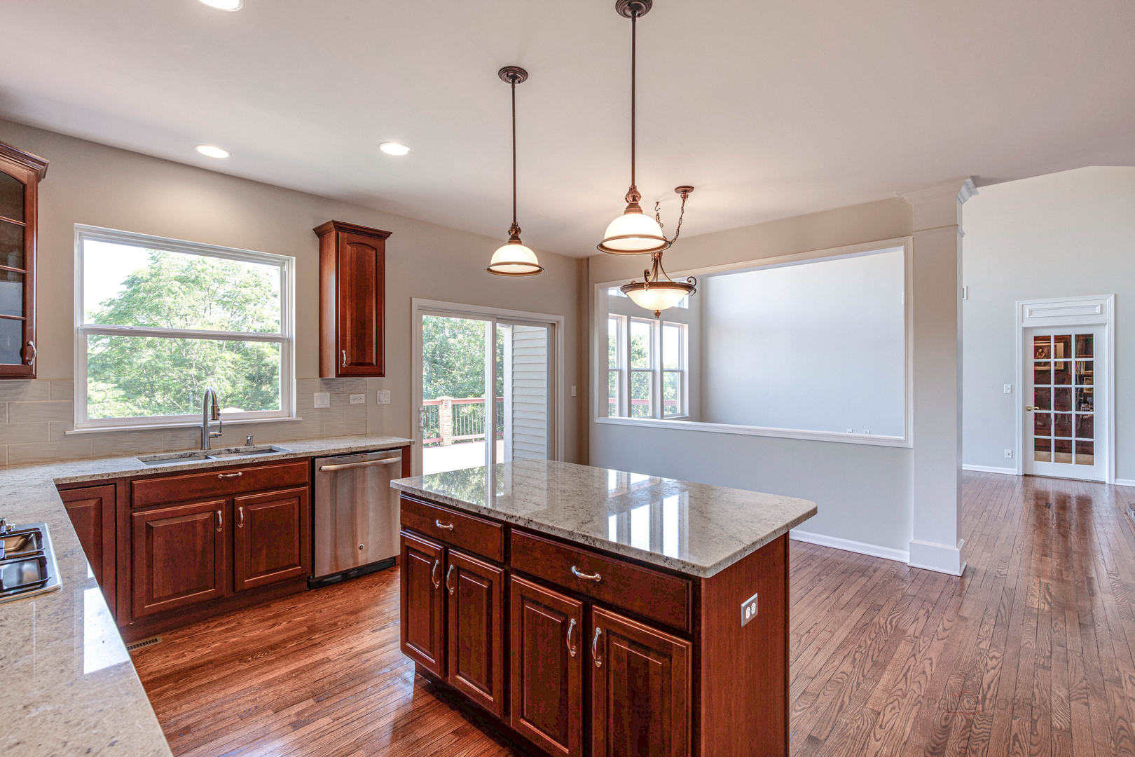 409 Wildflower Way Streamwood, IL 60107 - Photo 12 of 53 a kitchen with stainless steel appliances granite countertop wooden floors wooden cabinets a sink and a window