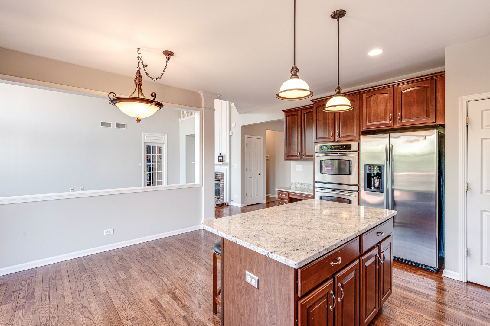 409 Wildflower Way Streamwood, IL 60107 - Photo 13 of 53 a kitchen with stainless steel appliances kitchen island granite countertop a refrigerator a stove and a wooden floors