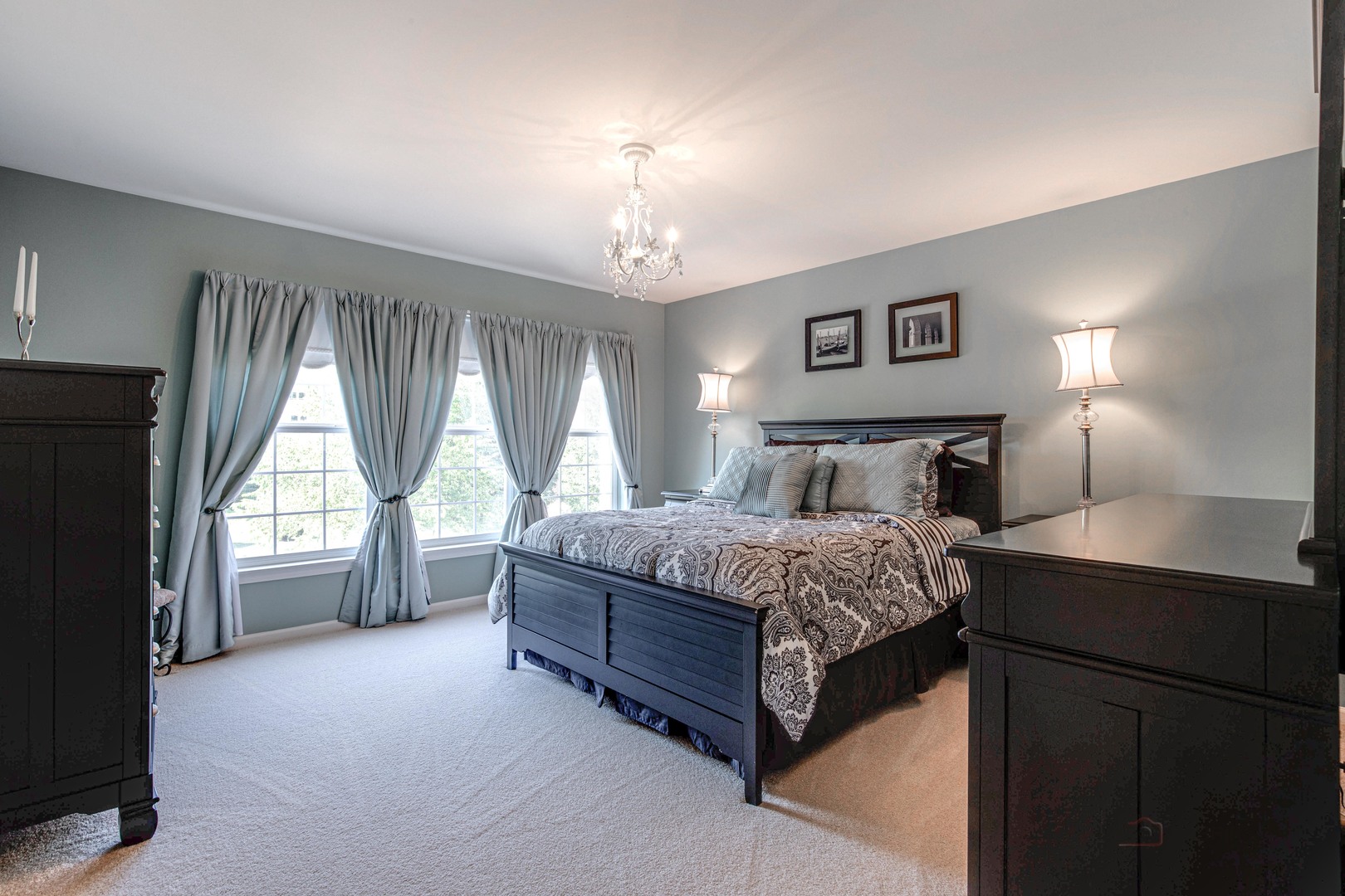 409 Wildflower Way Streamwood, IL 60107 - Photo 26 of 53 a spacious bedroom with a large bed and a chandelier next to a window