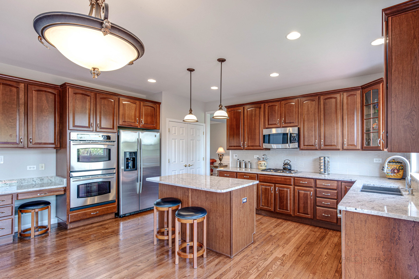 409 Wildflower Way Streamwood, IL 60107 - Photo 10 of 53 a kitchen with stainless steel appliances kitchen island granite countertop a stove a sink a refrigerator cabinets and wooden floor