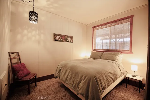 a bed sitting in a bedroom next to a window