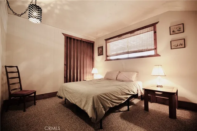 a bedroom with a bed a table and chair