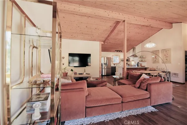 a living room with furniture a flat screen tv and a floor to ceiling window