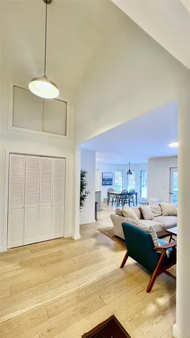 a living room with furniture a chandelier and kitchen view