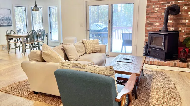a living room with furniture a large window and a dining table