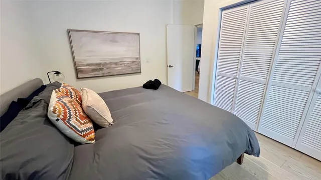 a bedroom with a bed and wooden floor