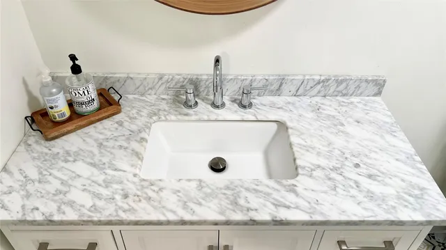 a bathroom with a granite countertop sink and a mirror